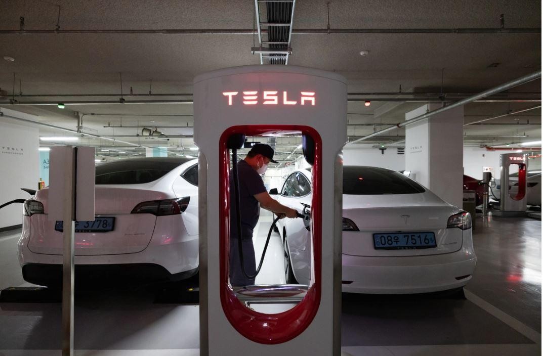 Một tài xế đang sạc Tesla Model 3 tại hầm gửi xe ở Suwon, Hàn Quốc. Ảnh: Bloomberg